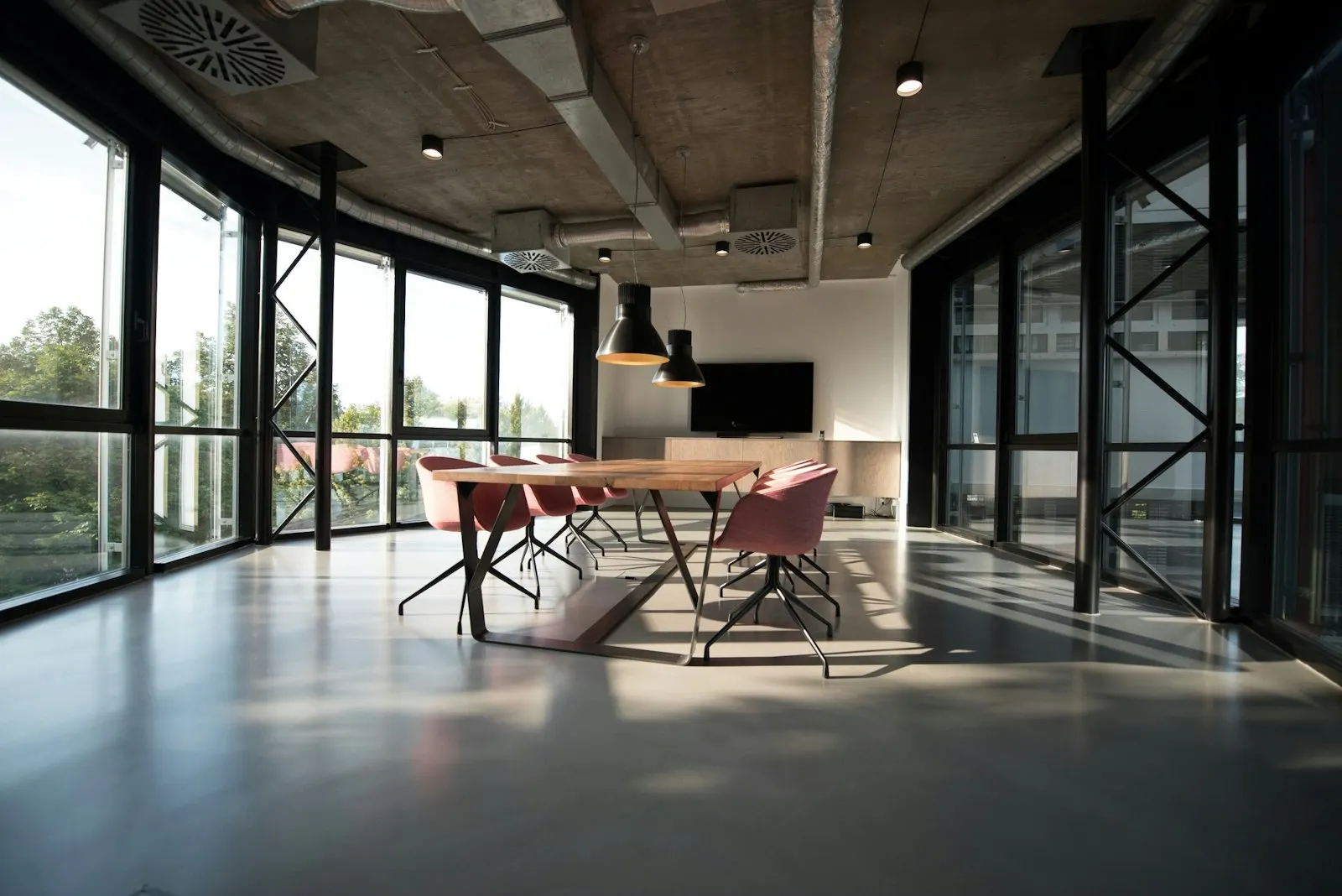 Loft-style workspace with an exposed ceiling, track lighting and long shared desks
